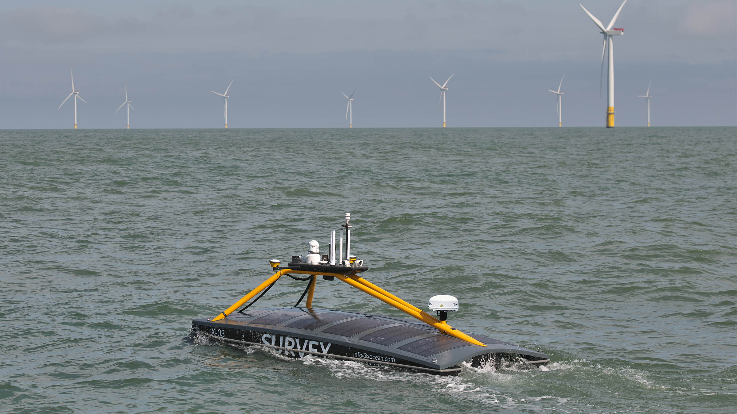 A USV passing wind turbines on the open sea